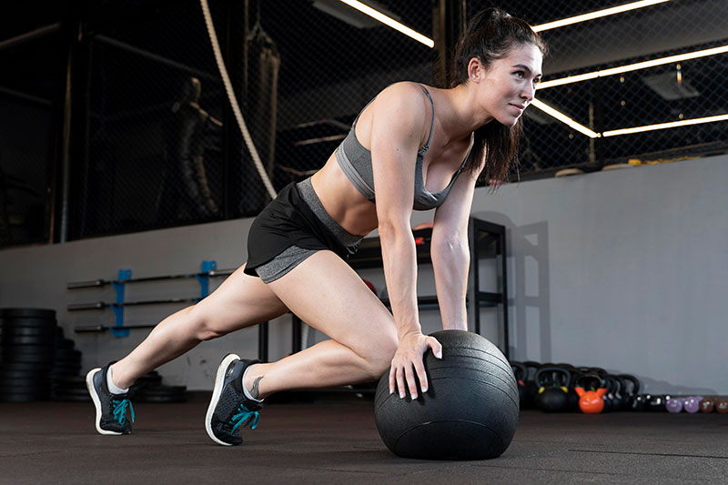 Mulher em cima de uma bola no treino de funcional