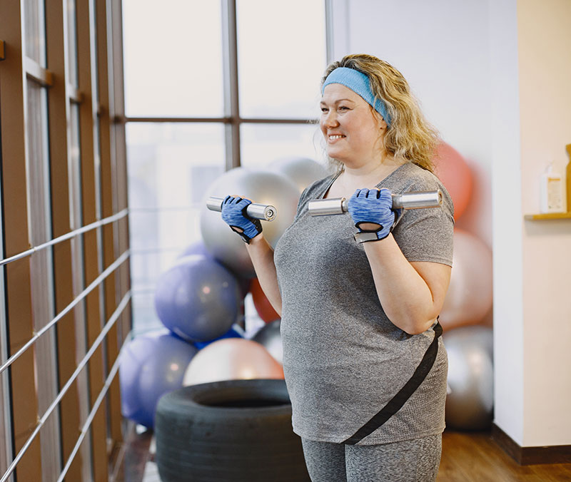 Mulher obesa treinando na academia